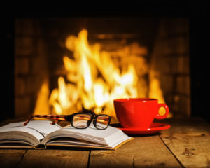 infertility during the holidays. Warm fire, book and red cup
