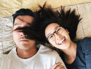 Sex and the ADHD Couple. Smiling woman and stressed out man together lying back on a bed